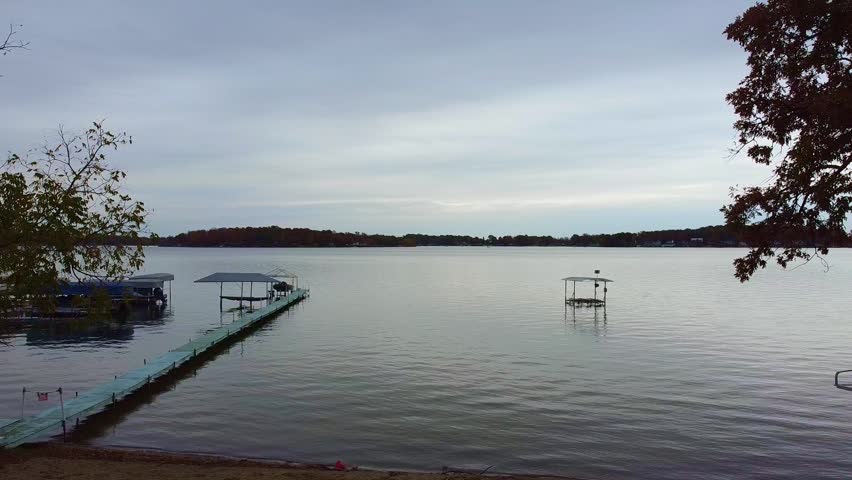 Drone footage of a Michigan beach, lake, and docked boats.