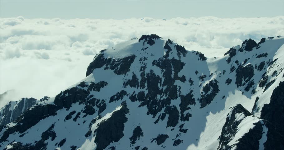 Snow-covered mountain tops under a clear sky, showcasing winter landscape, natural beauty, cold climate, and peaceful alpine scenery.