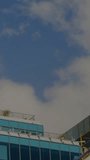Vertical video: Camera tilting down causing overlay sliding and unveiling rooftop to show details. Terrace, glass, urban, highrise, scaffolding, greenery, vertical video - Powered by Shutterstock - Get 15% off with code: PIKWIZARD15