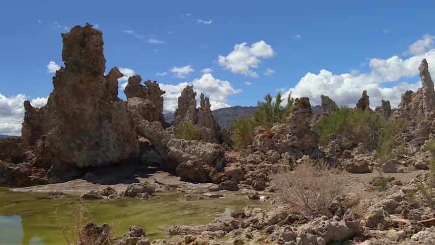 Mono Lake tufa columns standing against a blue sky with clouds in a unique desert ecosystem, California, America