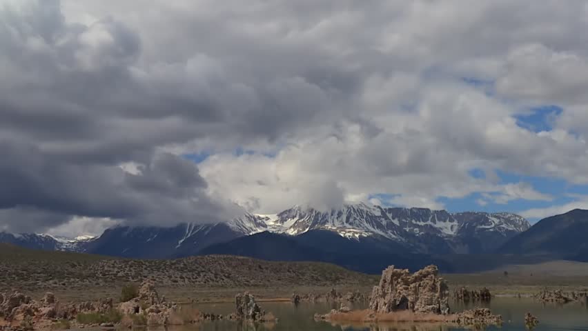 Mono Lake tufas rising from water, reflecting Sierra Nevada mountains and sky in California, USA