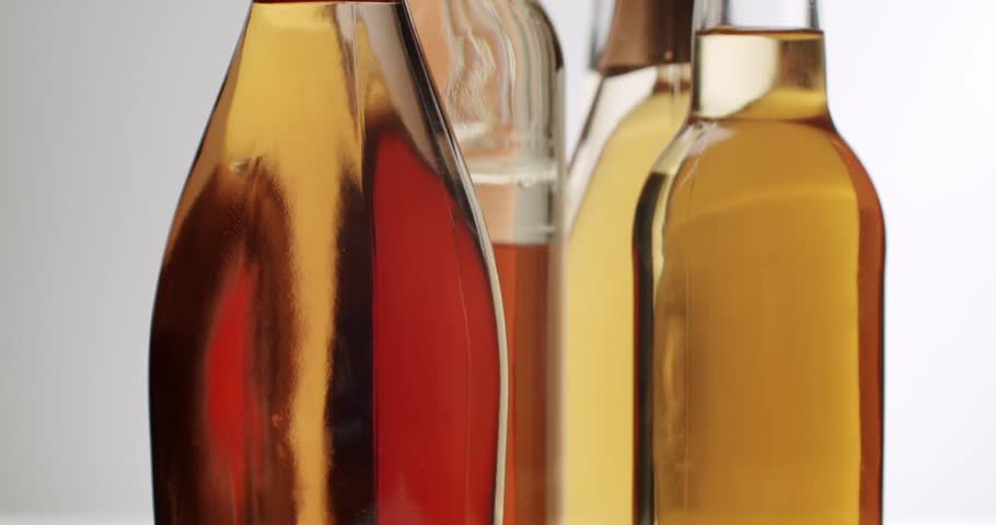 Several glass bottles with various alcoholic beverages such as whiskey, Selection of various alcoholic drinks, including rose, white wine, and sparkling wine,