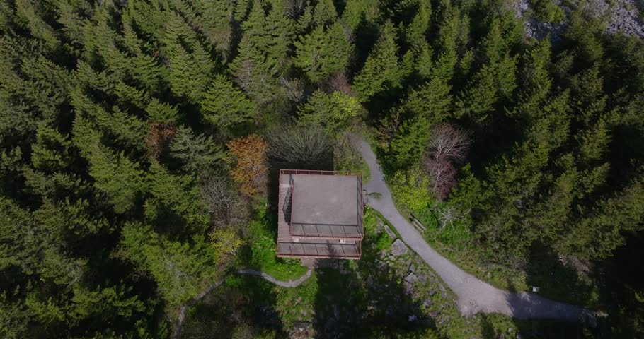 Aerial pullback tilt up from concrete viewing platform of Spruce Knob peak, forested landscape