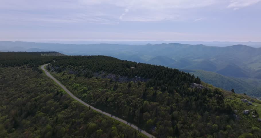 Aerial orbit, winding ridgeline road through dense forest near Spruce Knob summit
