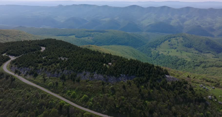 Elevated drone orbit around curving mountain forest road, Spruce Knob West Virginia