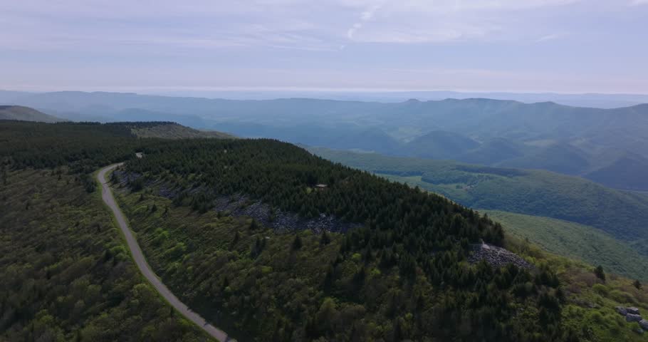 Smooth drone ascend orbit above rolling forests revealing layered Appalachian mountain horizons, Spruce Knob WV