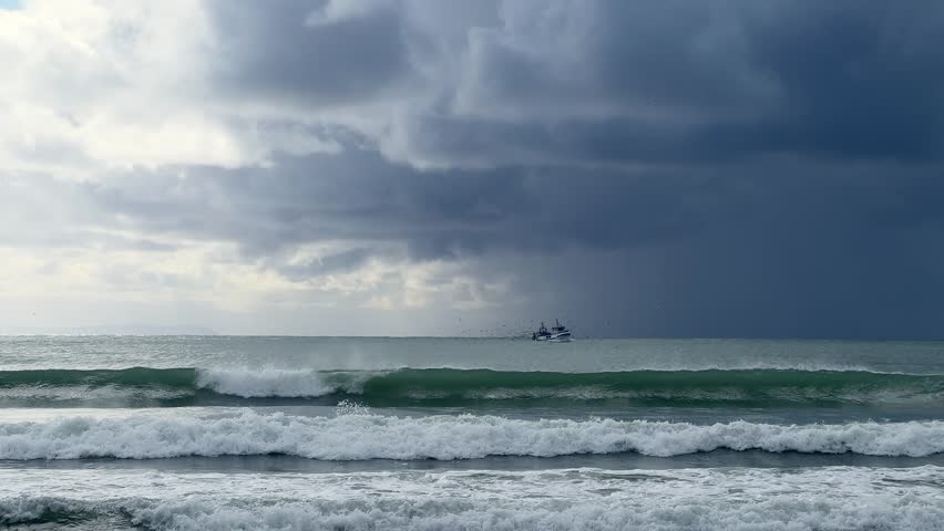 Beach scene at sunset, where powerful waves