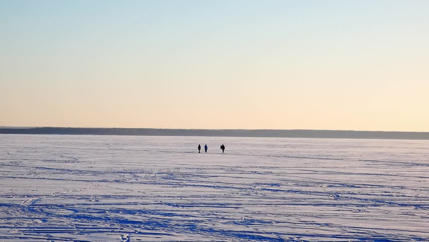 Two people walk on a frozen lake with a horse as the sun sets. The bright sky and ice create a simple, clear view of a winter day. It shows nature and outdoor life.