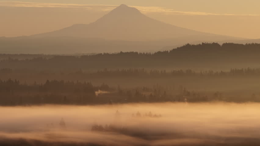 The scenic Mount Hood rises from the forested landscape of northern Oregon. This iconic Pacific Northwest mountain is part of the Cascade Mountain Range.