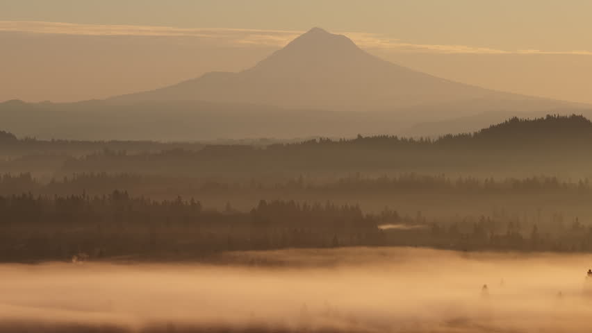 The scenic Mount Hood rises from the forested landscape of northern Oregon. This iconic Pacific Northwest mountain is part of the Cascade Mountain Range.