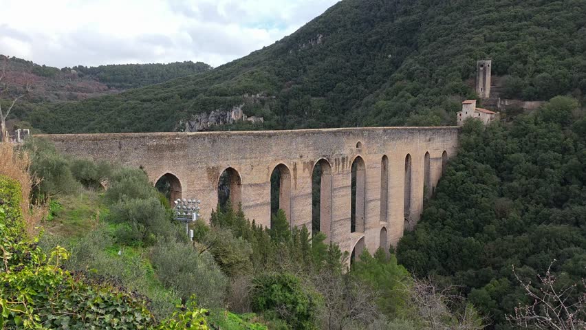 The Ponte delle Torri in Spoleto is a stunning 230-meter-long medieval aqueduct with ten arches, soaring 80 meters over a deep gorge