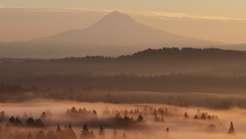 The scenic Mount Hood rises from the forested landscape of northern Oregon. This iconic Pacific Northwest mountain is part of the Cascade Mountain Range.