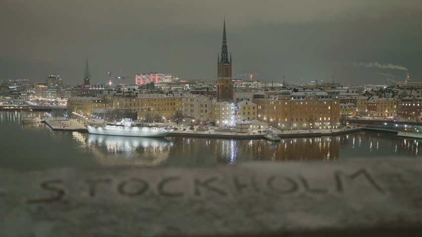 A stunning nighttime cityscape of Stockholm, showcasing illuminated buildings, waterways, and reflecting lights. The scene captures the beauty and charm of a vibrant European city after dusk.