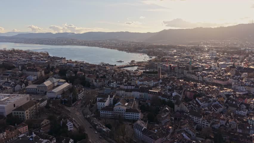 Romantic sunset over Zurich: drone view of the old town, lake, and snowy mountains. Zurich, Switzerland