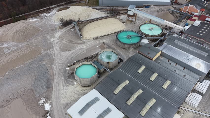 Aerial view of industrial complex. Shows water treatment tanks and storage areas. Includes sand piles and factory buildings. Drone footage reveals facility layout. Suitable for environmental or industrial stock - Dobrany, Czech - Feb,7,2026