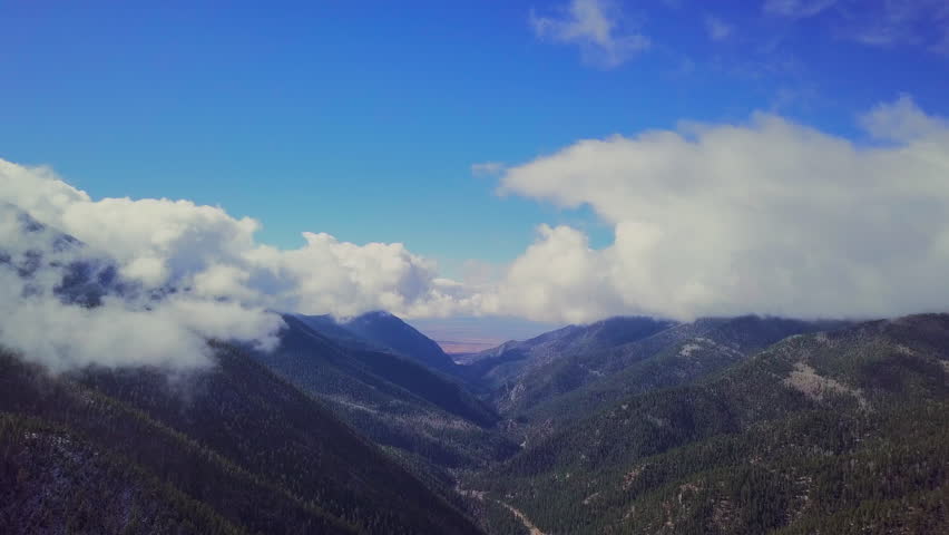 High Mountain Road in valley with blue sky and clouds, New Mexico, Pine Trees, American Southwest, 4K Drone aerial