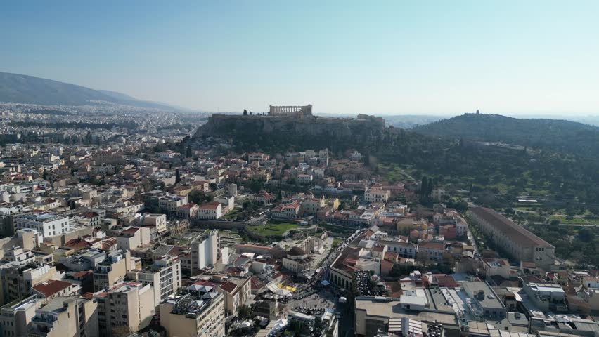 Breathtaking aerial view of Athens showing the Acropolis, capturing the vibrant city below with clear blue skies.