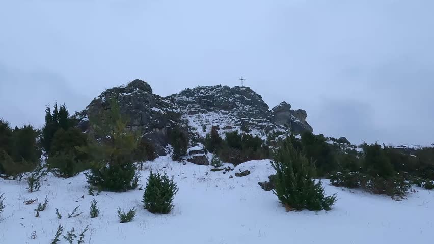 Low angle shot of the rocky Biaklo summit with a cross during winter in Poland.
