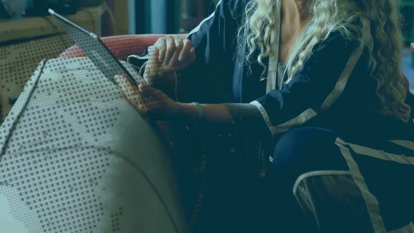 Mature woman lifting tablet from cushion tapping and swiping tech app, smiling and pumping fist. Technology, leisure, relaxation, modern, lifestyle, entertainment, communication