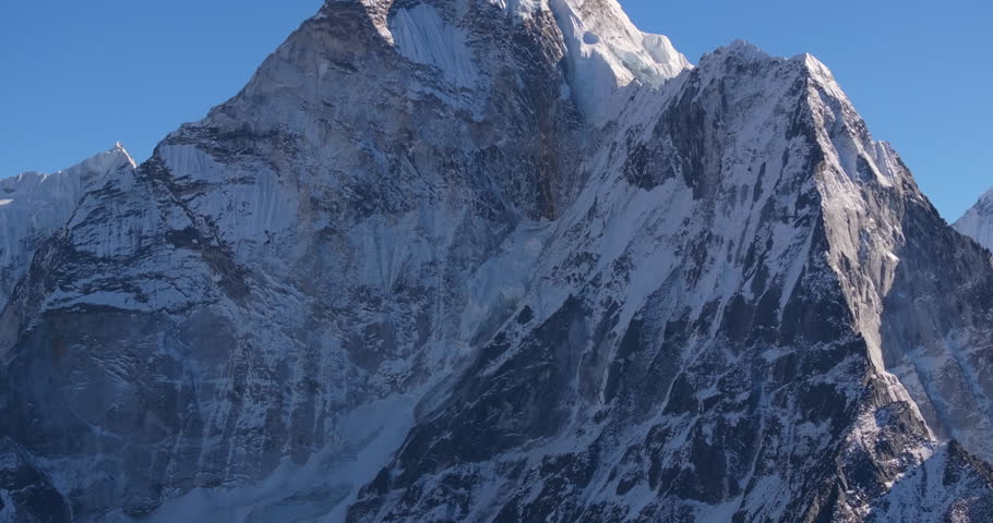 Tilt-up aerial drone shot revealing Mount Ama Dablam in Nepal’s Khumbu region, viewed from Nangkartshang Peak. Dramatic Himalayan perspective along the Everest trekking landscape.