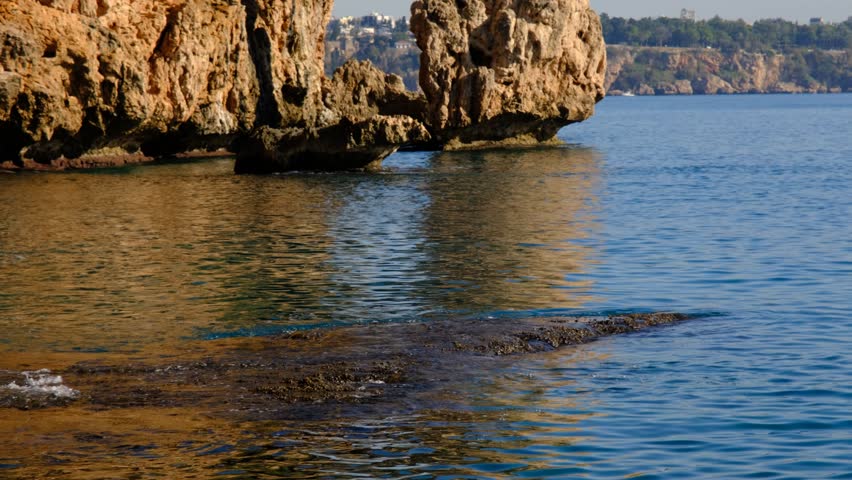 Calm Sea Waves Against Rocky Cliffs. Serene Coastal Cliffs with Soft Wave Motion. Tranquil Cliffside Ocean View. Relaxing Seascape – Waves Touching Rocks.