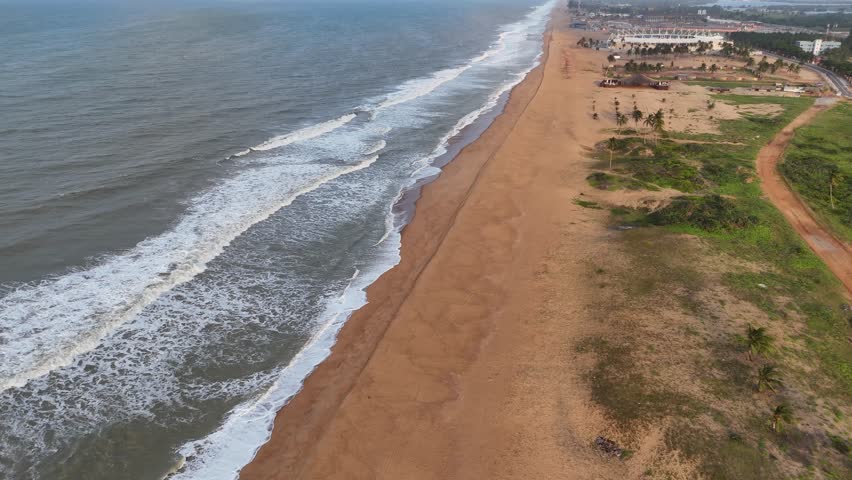 drone flight over the wild beaches of Ouidah golden sand beach with ocean waves in west africa travel destination in benin