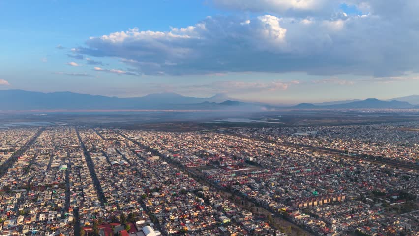 Aerial panorama of Valley of Mexico featuring urban haze and volcanic silhouettes
