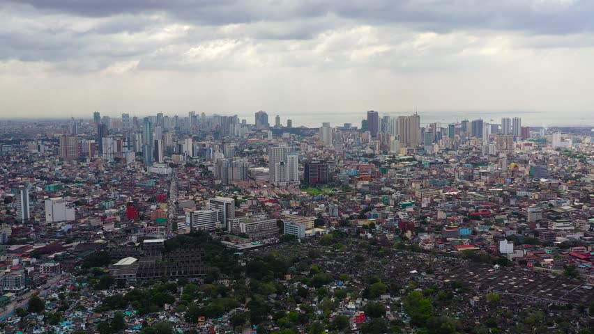 Aerial view of Manila, Philippines, showing the bustling cityscape, skyscrapers, and urban life along the waterfront.