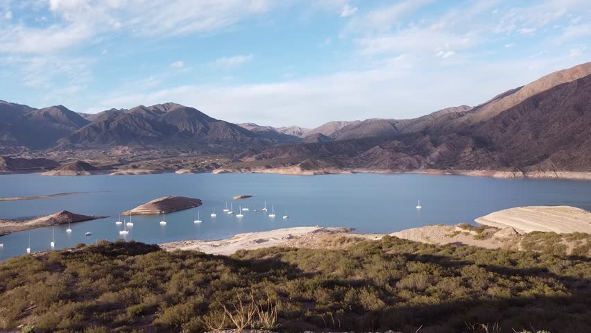 Aerial view captures Potrerillos lake in Mendoza, Argentina. Scenic landscape, water activities. Peaceful, serene mood. Tourist destination