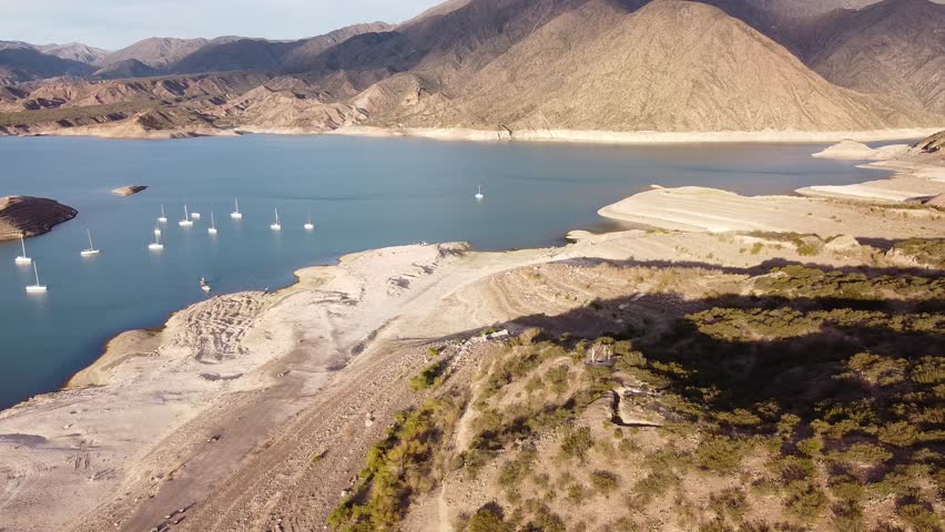Drone view of a scenic lake surrounded by mountains in Potrerillos, Mendoza, Argentina. Beautiful, serene. Travel, recreation, nature