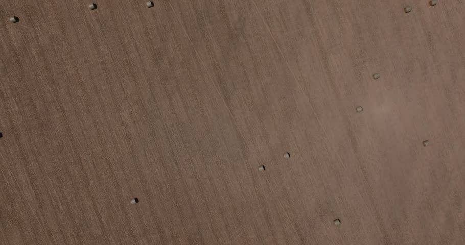 Top down drone backdrop of soil texture and hay bale placement in empty agricultural fields, Breadbasket of America