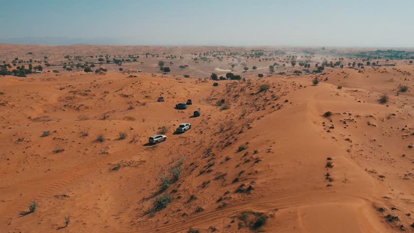 Off-roaders drive their 4WD vehicles through the deep desert during a desert drive in the UAE