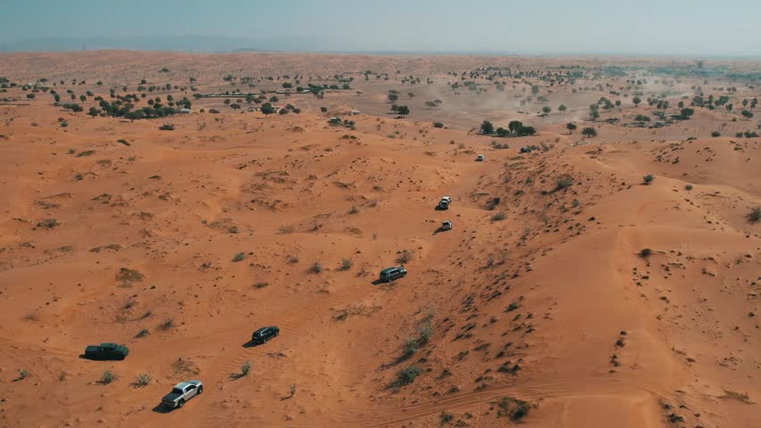 Off-roaders drive their 4WD vehicles through the deep desert during a desert drive in the UAE