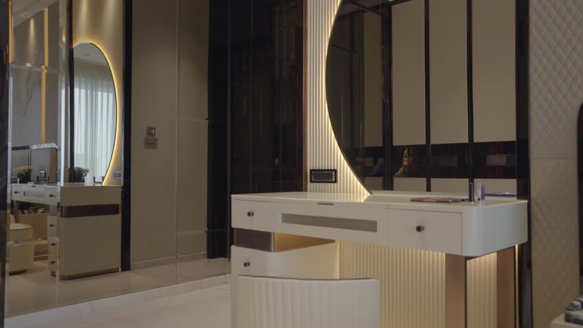 Vanity table positioned below a vertically ribbed half round illuminated mirror,