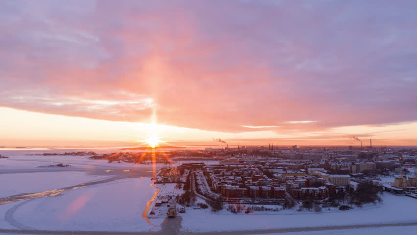 Hyperlapse drone shot of a dramatic winter sunset above the cityscape of Helsinki