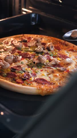 Homemade pizza baking in the oven with delicious toppings