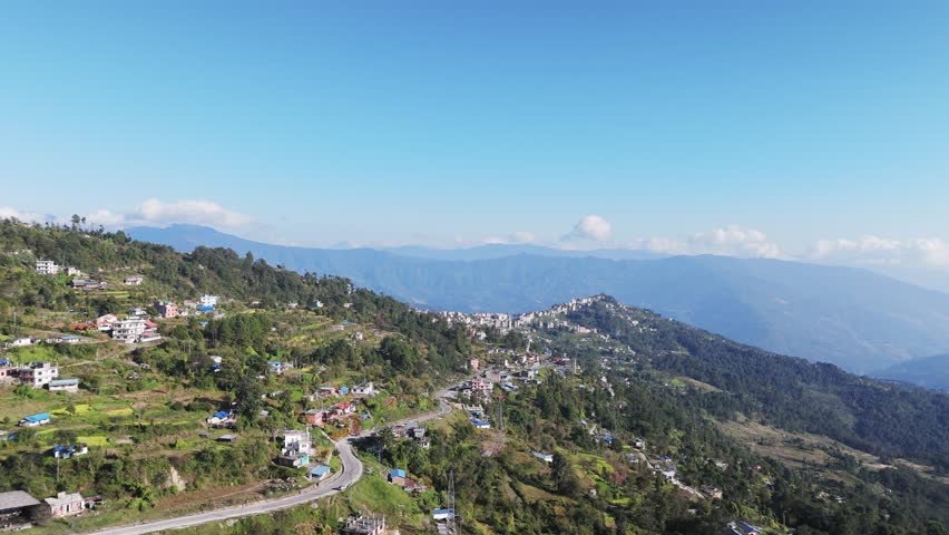 Drone view from Dolakha city reveals Himalayan mountains rising above hills and settlements creating a scenic aerial landscape in Nepal