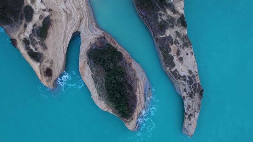 Top down aerial drone view of unique geological rock formations at Canal d'Amour, Sidari, Corfu, Greece, with textured sandstone cliffs and blue Ionian Sea water