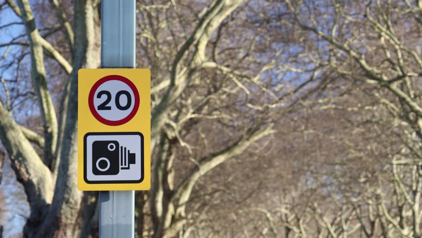 Speed limit and traffic camera sign, establisher blurred background