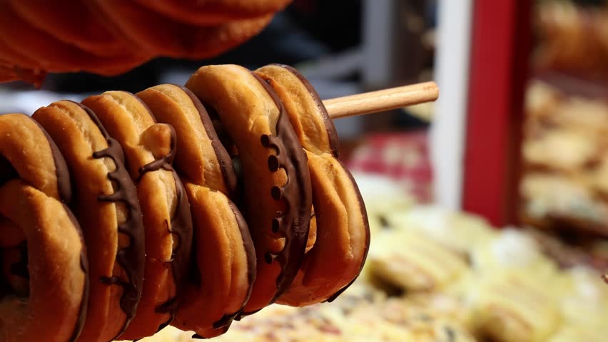 Chocolate covered donuts in pretzel shape on a food market