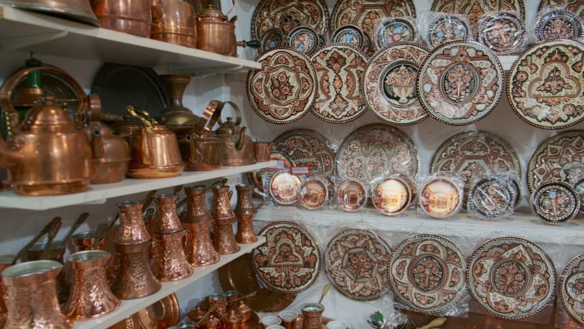 Panning footage of traditional hammered copper kitchenware and decorative oriental plates with intricate traditional bosnian patterns. Artisanal market in Mostar, Bosnia and Herzegovina
