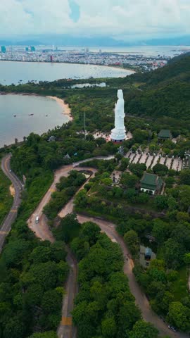 religious Lady Buddha monument at Linh Ung pagoda and buddhism temple, Asian religion and spirituality, Son Tra peninsula, Da Nang, Vietnam 4k aerial drone view, vertical video