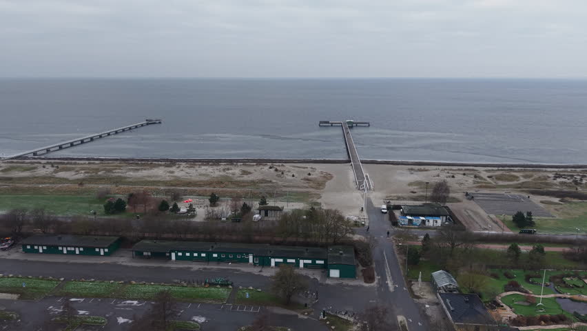 Drone Shot of Beach in Malmo Sweden on Cold WInter Day, Piers and Sandy Shore on Baltic Sea