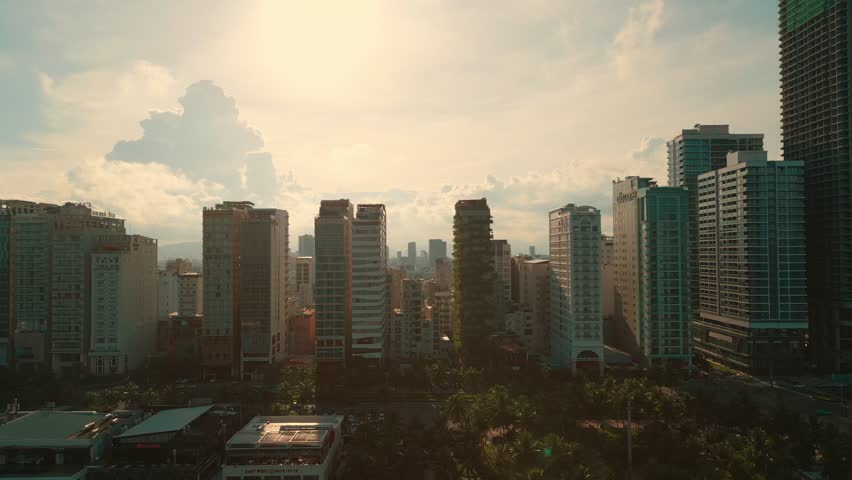 sunny sunset in Vietnamese coastal Da Nang city, My Khe sand beach and touristic My An and Son Tra district with modern skyscraper hotels and resorts, blue sea of Danang, Vietnam, aerial drone view 4k