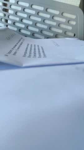 A woman's hand underlines the text on the paper with a pink marker. Synopsis, study. Documents, contract