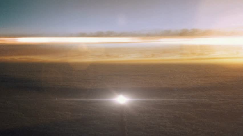 A space rocket launches upward through thick clouds at sunset, glowing against the sky as fiery exhaust contrasts with warm horizon colors during a dramatic ascent.