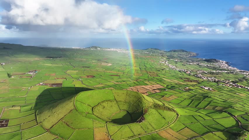 Rainbow over Pico Dona Joana surrounded by patchwork landscape, Terceira. Aerial