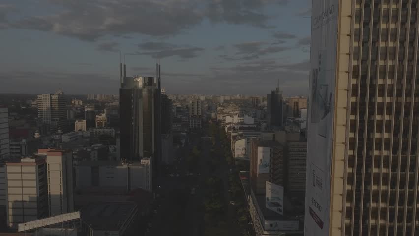 Aerial drone shot of Kenyatta avenue street in Nairobi city scanning through the city scape with traffic and people movement