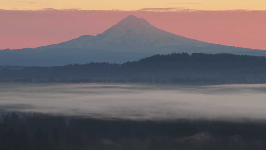 The scenic Mount Hood rises from the forested landscape of northern Oregon. This iconic Pacific Northwest mountain is part of the Cascade Mountain Range.