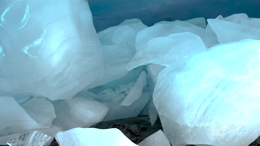 Smooth ice chunks inside ice cave under Brewster Glacier. Ice melting, water dripping.